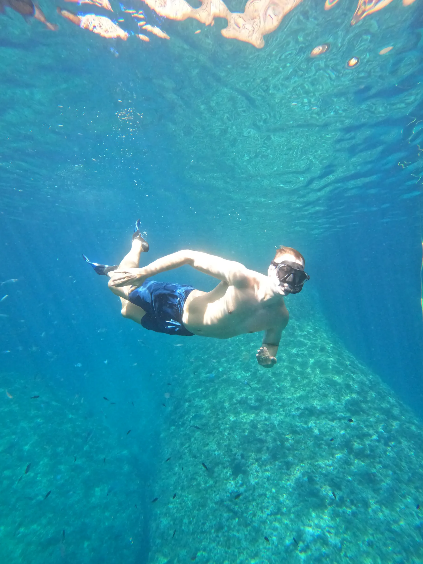 Freediving down through clear blue water